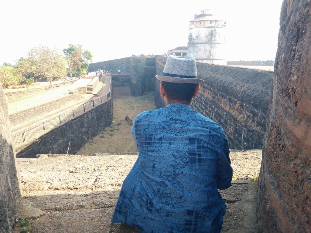 portrait of a man facing the Aguada Fort in Goa 